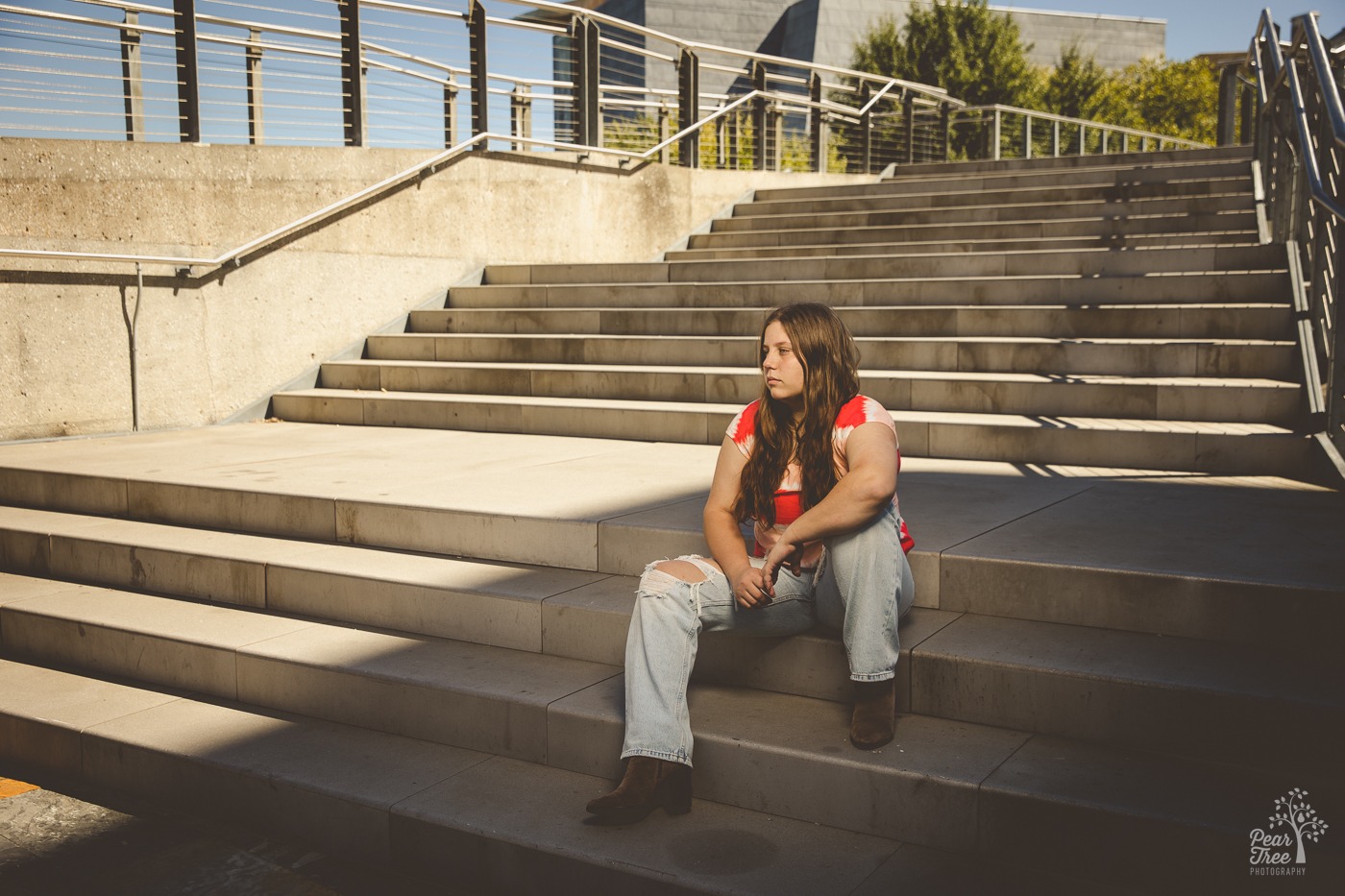 Senior girl sitting seriously on cement steps in downtown Chattanooga
