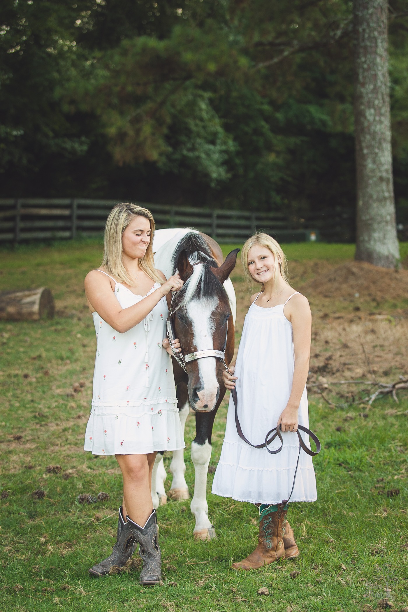 Two sisters in white dresses with their misbehaving paint horse in Woodstock