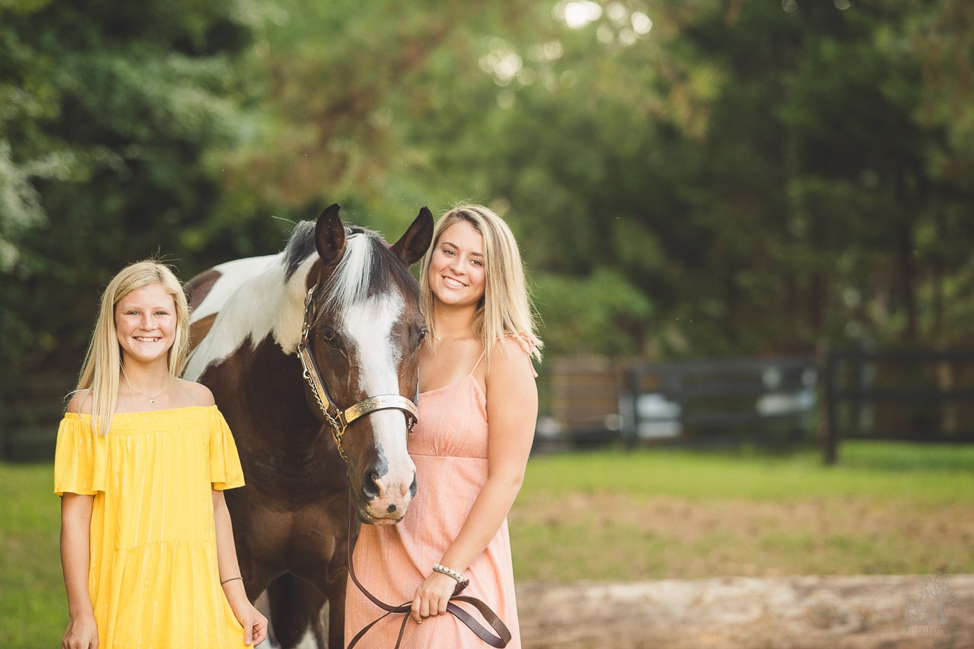 Two sisters smiling during their paint horse photo shoot in Woodstock, GA