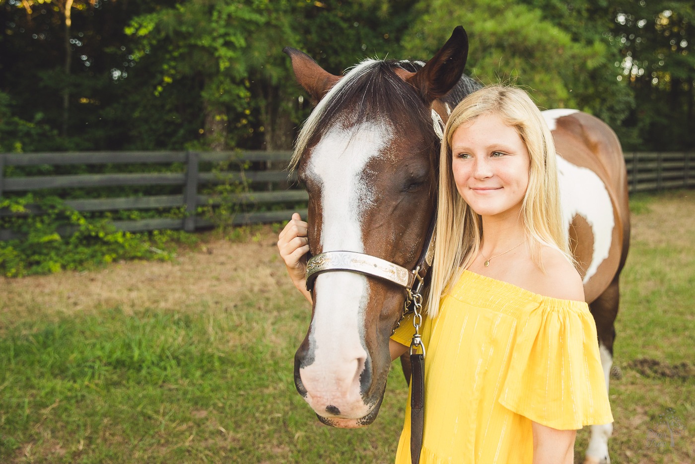 Young girl smiling and holding her paint horse close