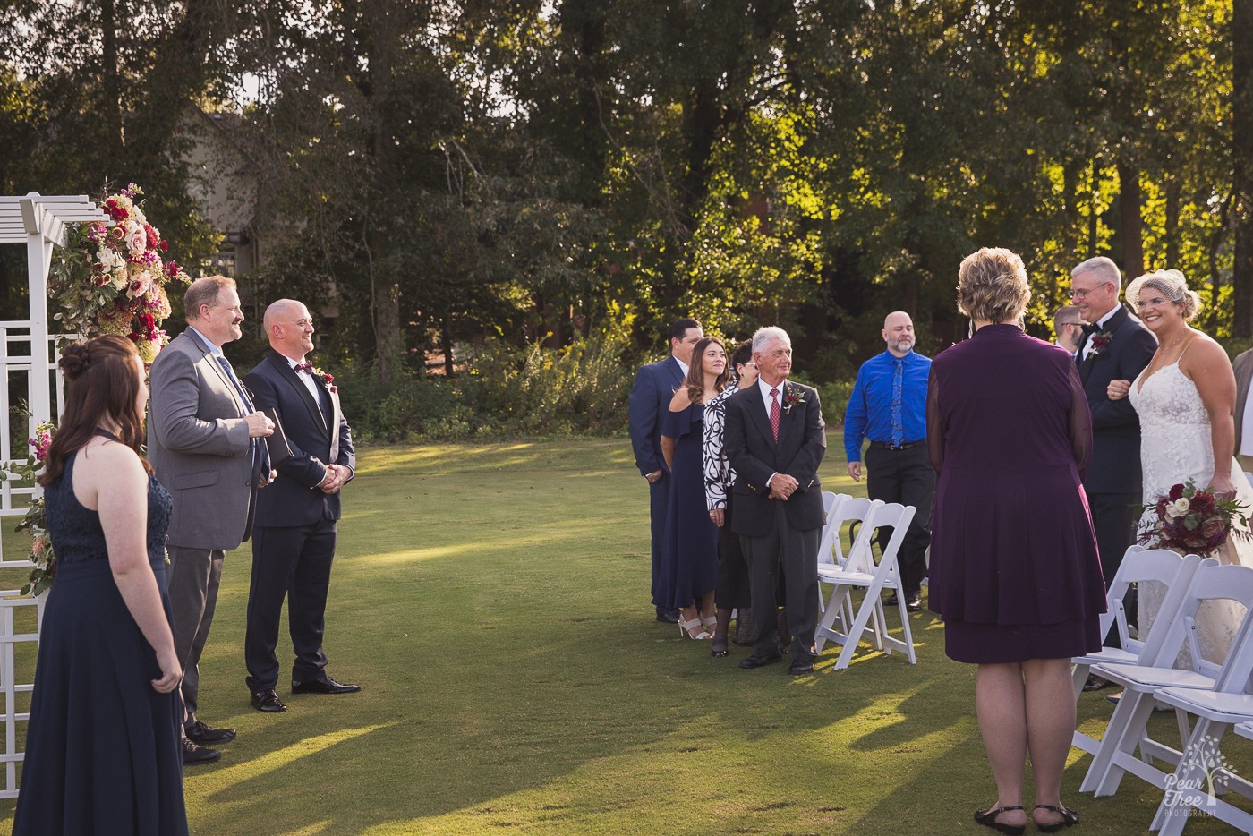 Groom watching his bride walked down the aisle by her dad