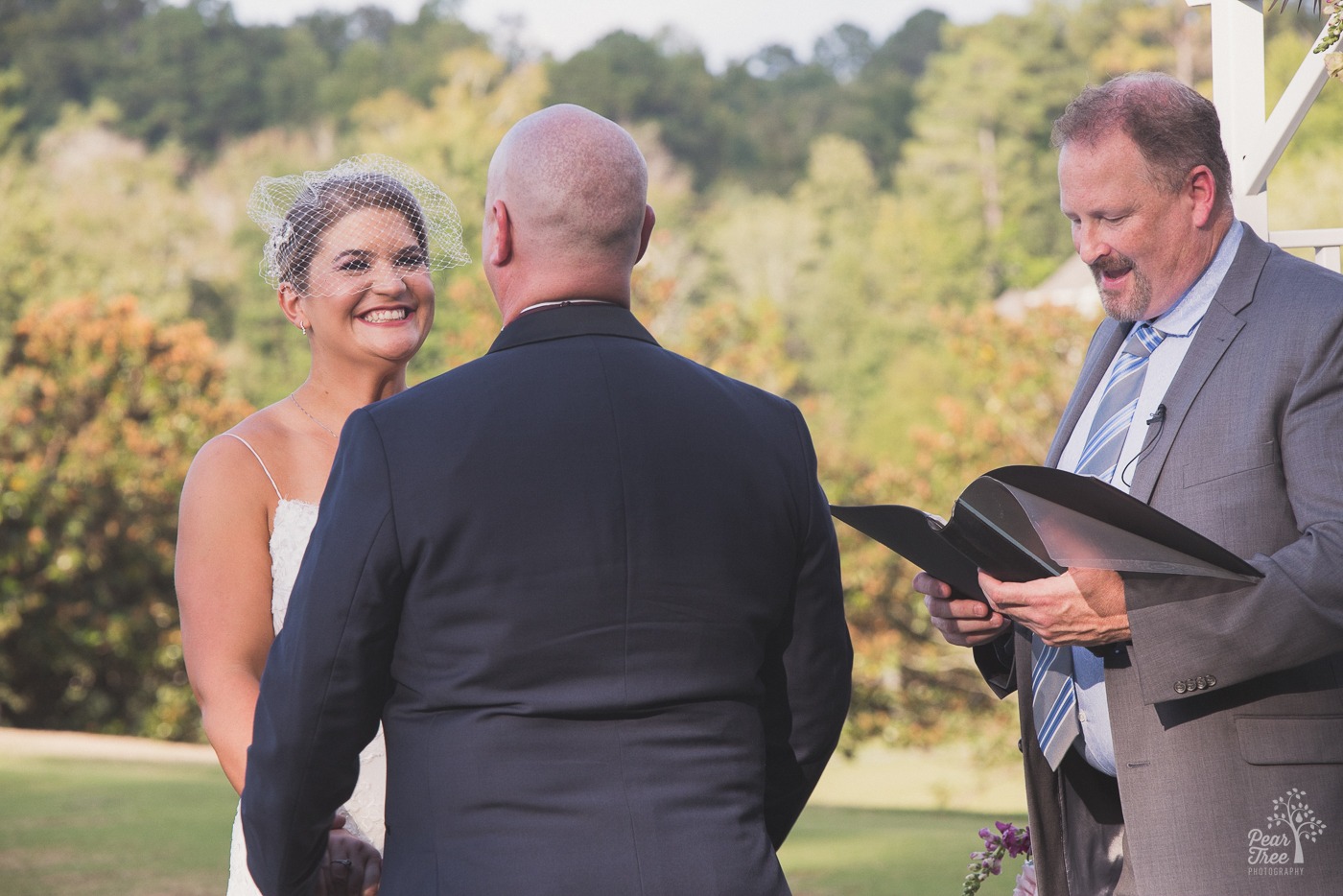 Bride smiling at groom during Cumming Polo Fields wedding ceremony