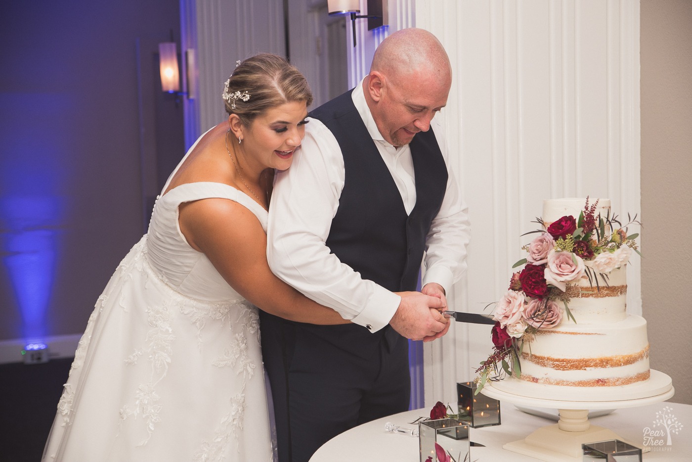 Bride and groom cutting into wedding cake at Cumming Polo Fields