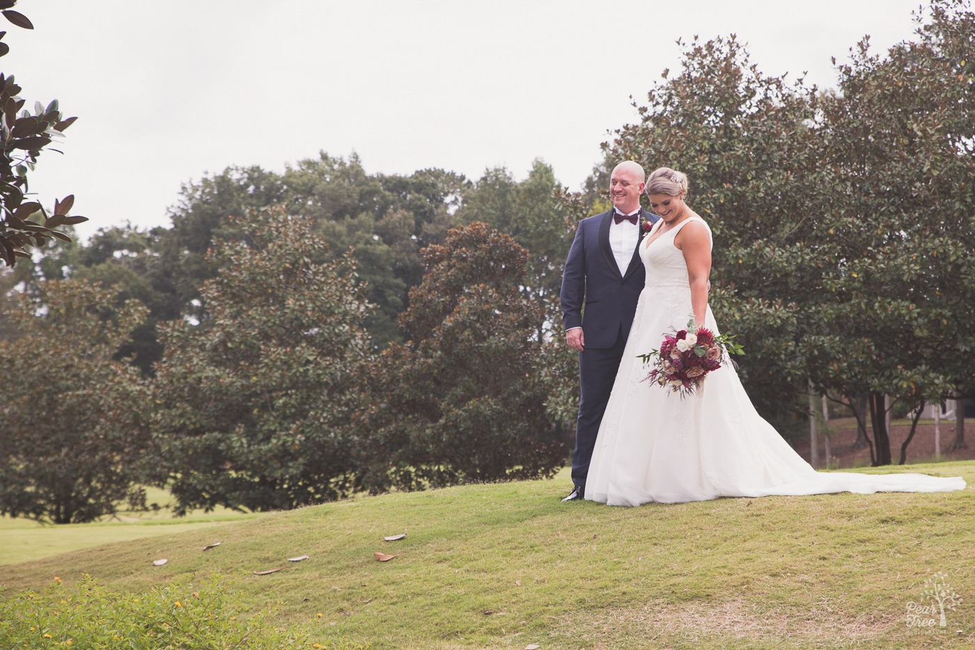 Groom smiling and bride looking down at her bouquet