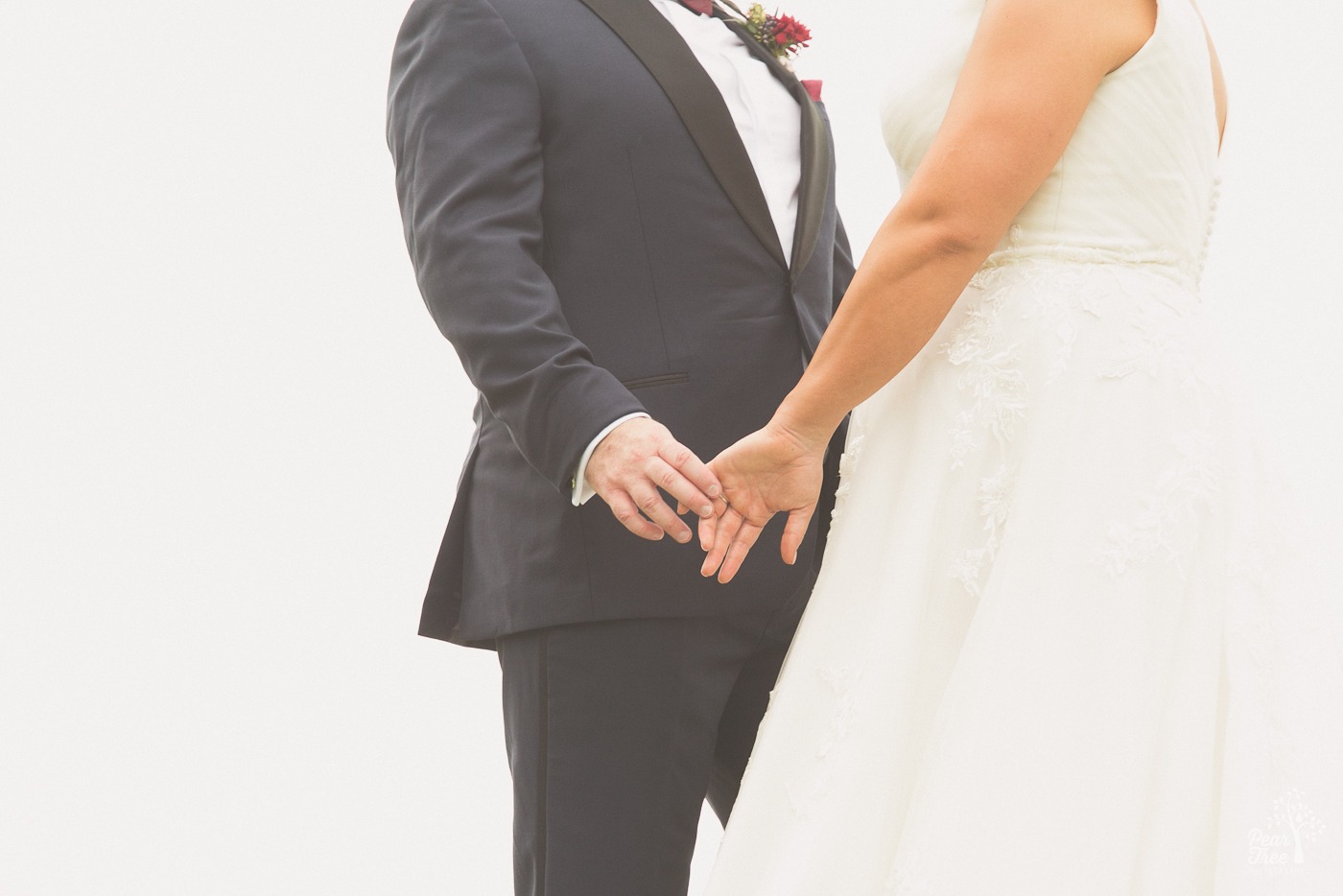 Anonymous ride and groom touching fingers while standing close