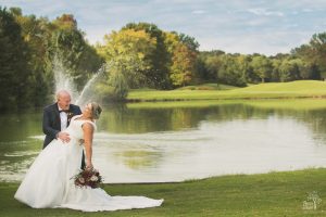 Bride and groom laughing as he dips her during Cumming Polo Fields wedding photos