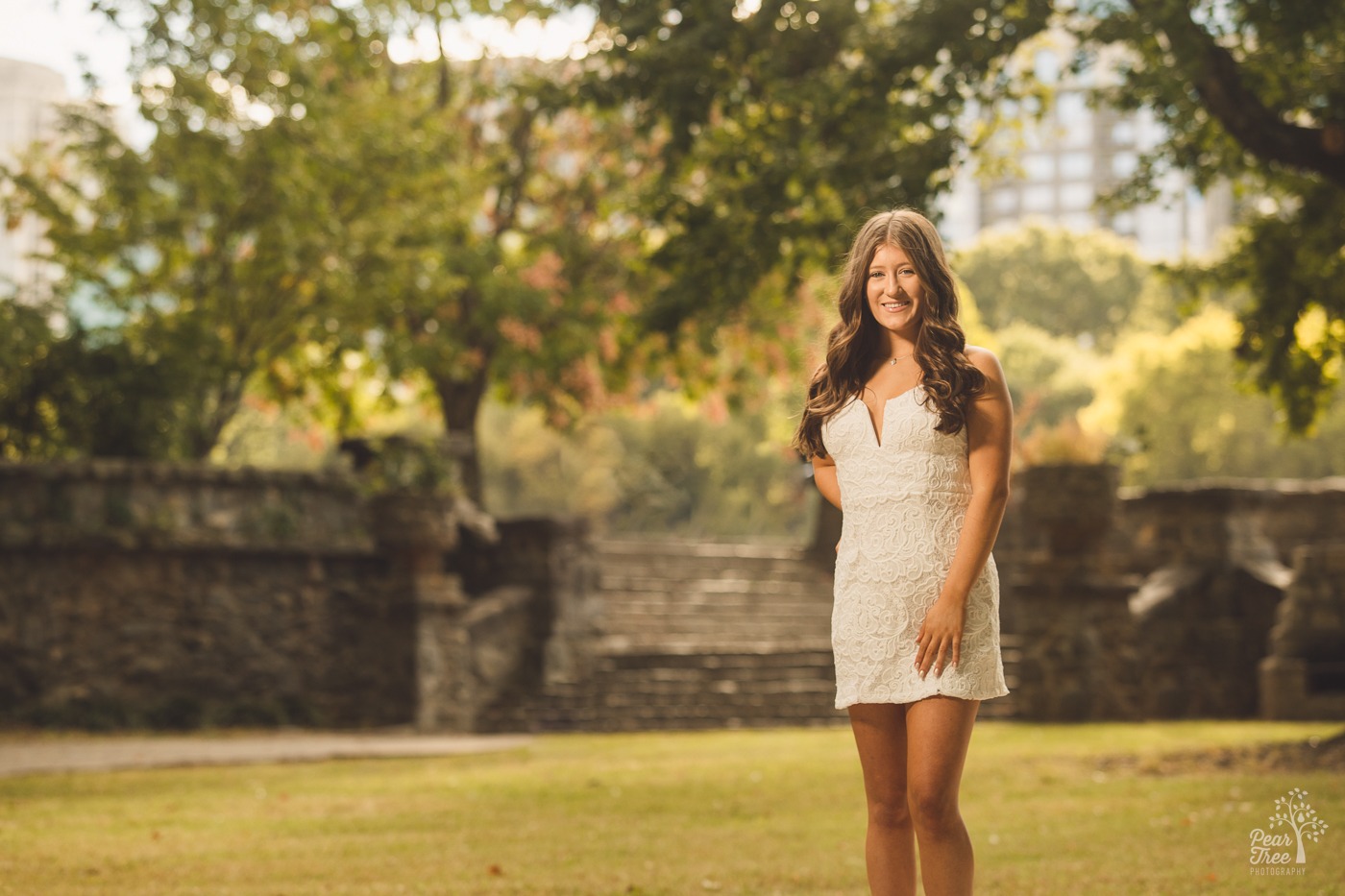 Pretty teenage girl in white lacy dress smiling in Piedmont Park