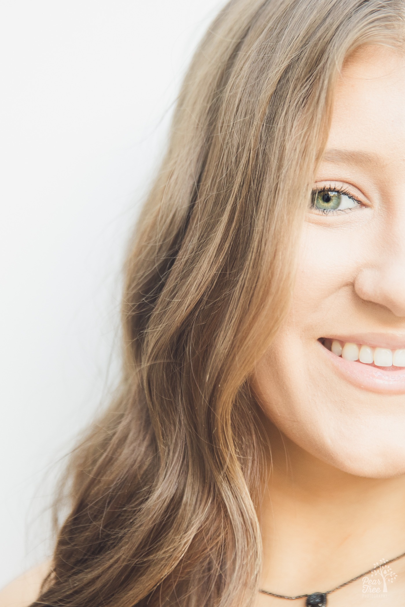 Half face vertical photograph of a striking high school senior girl with green eyes