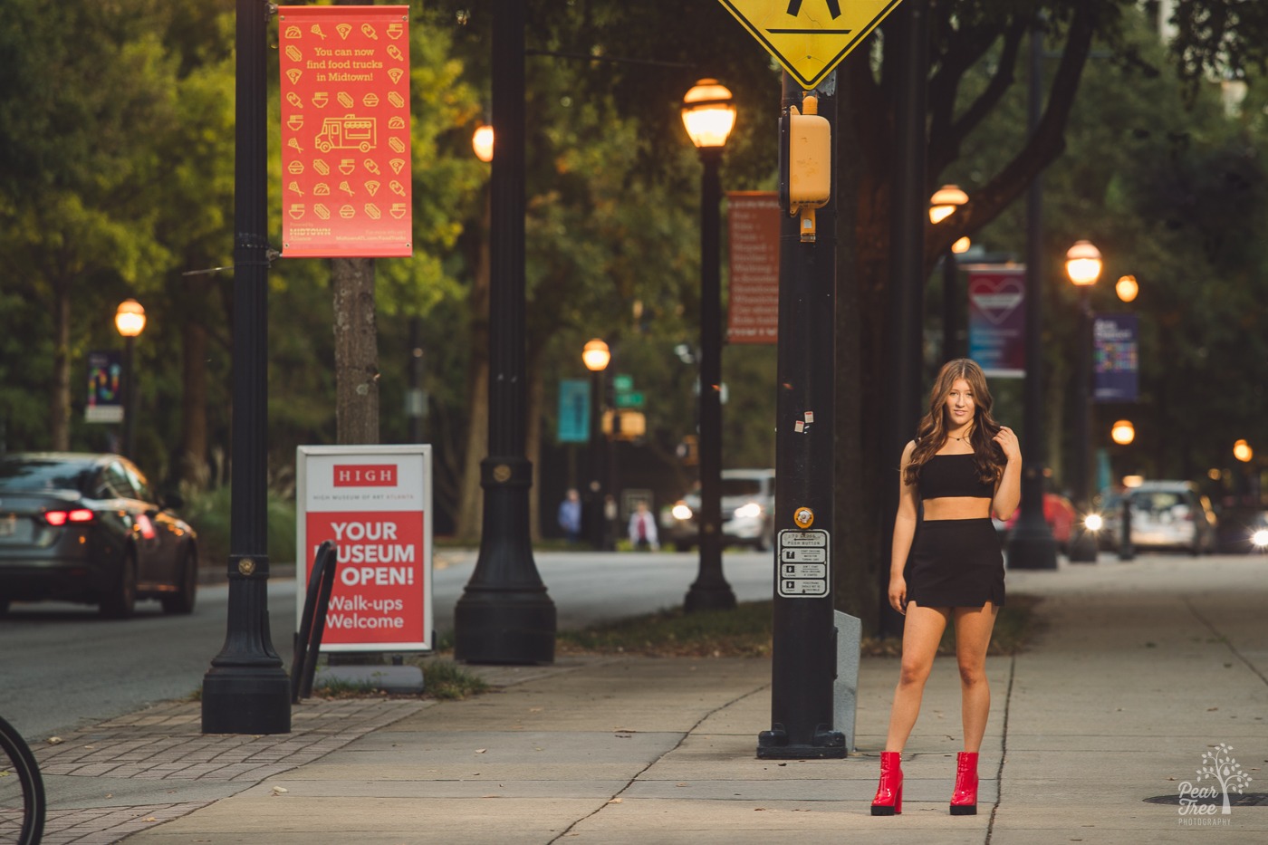 High school senior girl photos in Midtown Atlanta on a sidewalk under lit streetlights