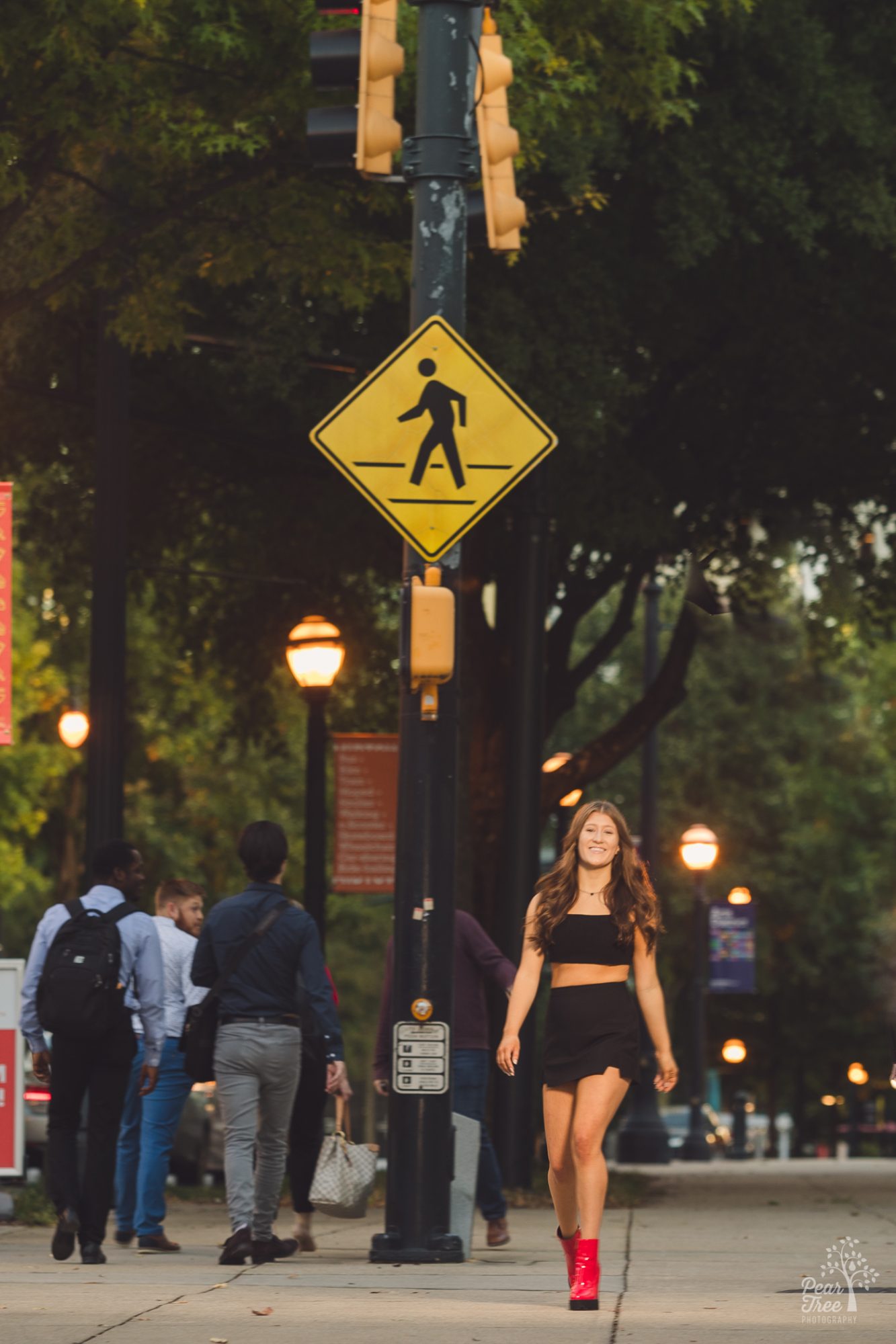 High school girl in black skirt and top with chunky red boots walking down midtown Atlanta sidewalk