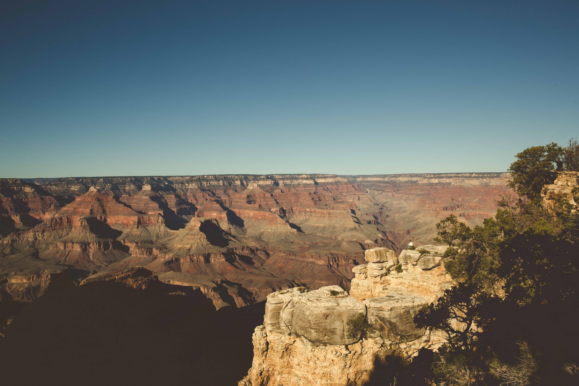 A single person sitting alone at Shoshone Point at the Grand Canyon