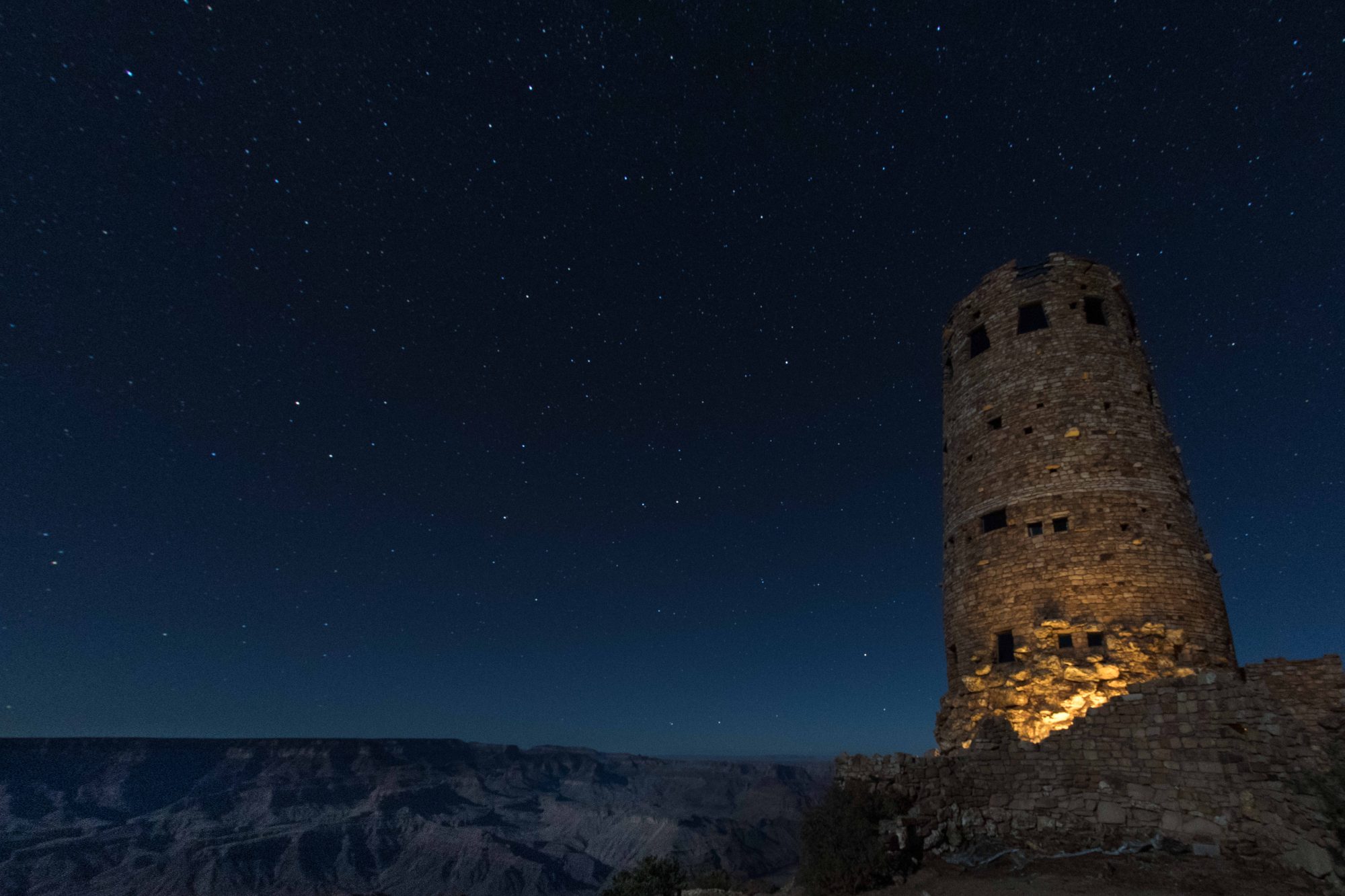 Night photograph of the Grand Canyon, the Watch Tower, and starlit sky