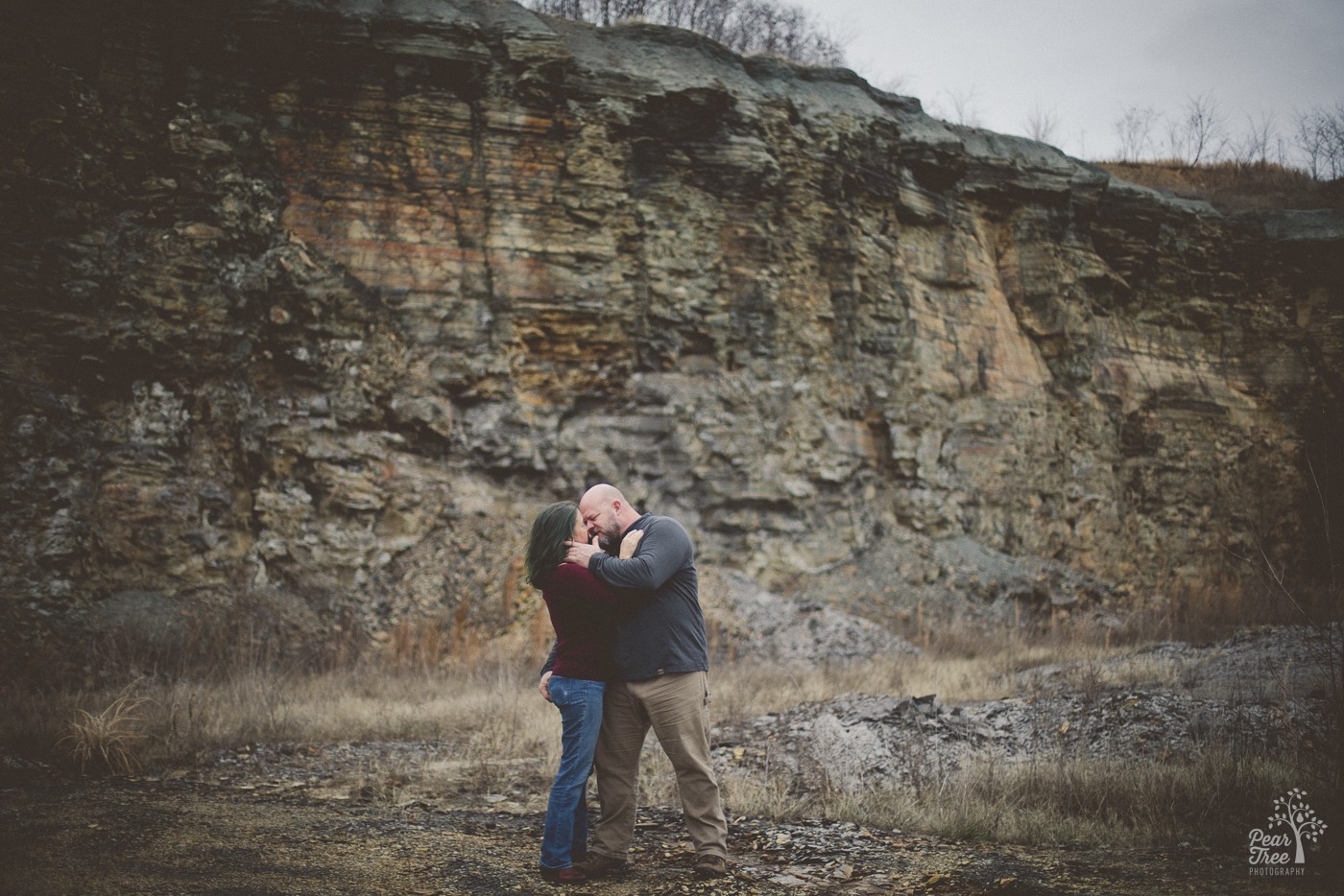 A couple standing close and almost kissing while he pulls her face in and holds her booty