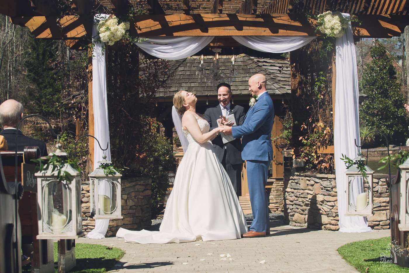 Bride leaning back and breathing a big sigh of relief when pronounced married at Rocky's Lake Estate wedding