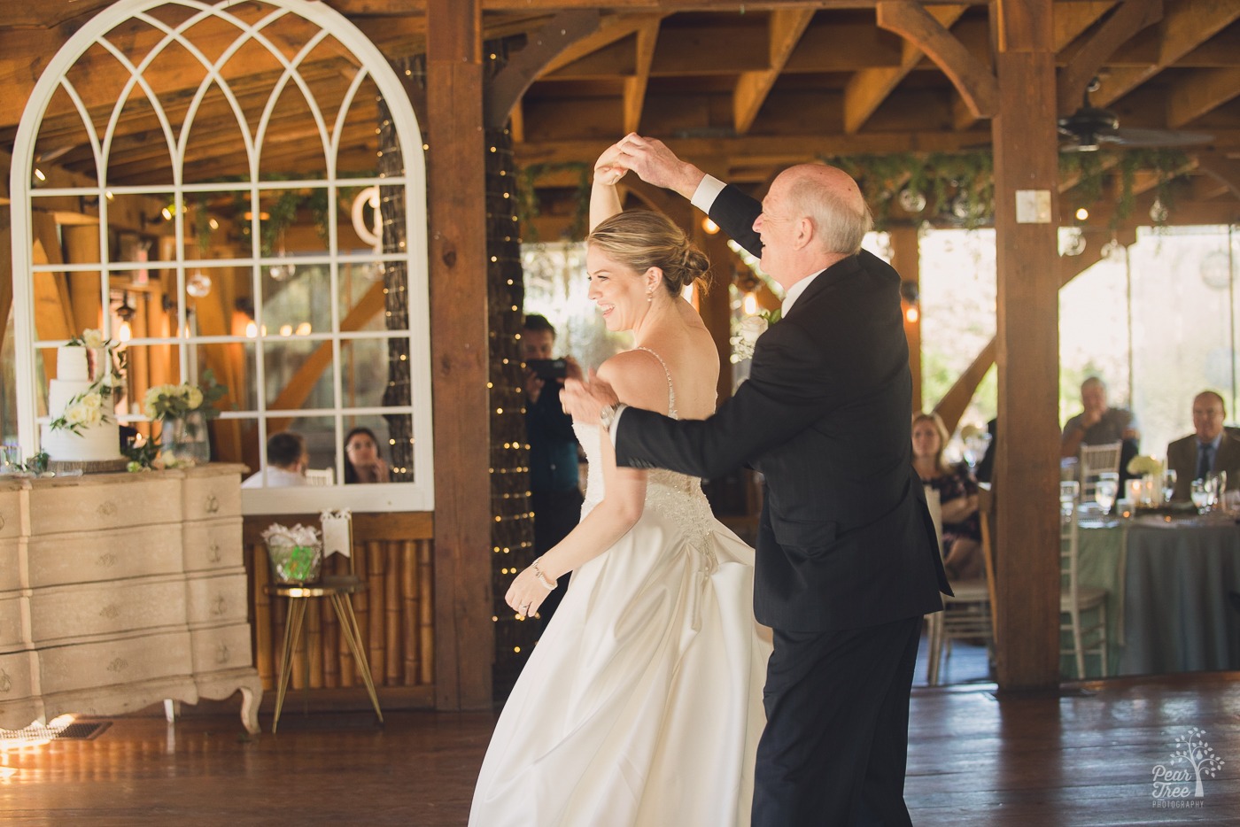 Father of the bride twirling his daughter during their father daughter dance at Rocky's Lake Estate