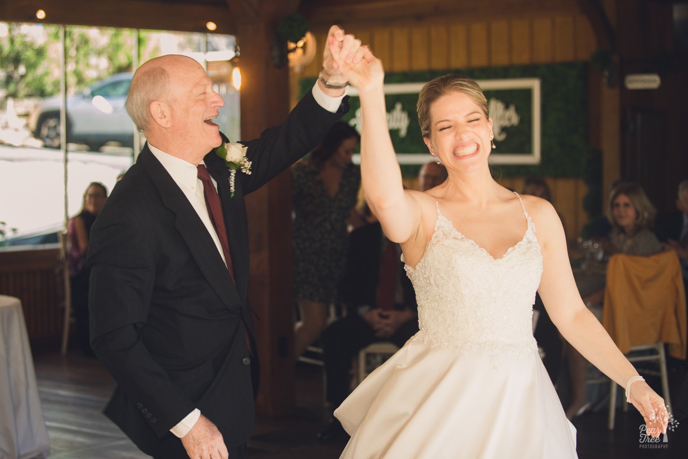Bride and her dad laughing while they dance and spin