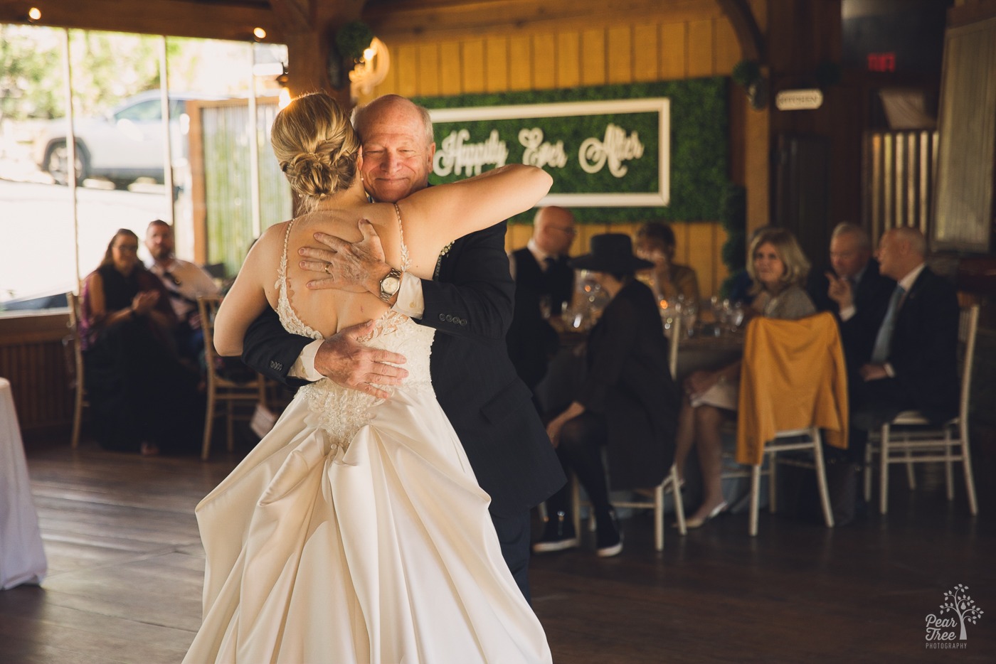 Father hugging his daughter close at the end of their dance on her wedding day