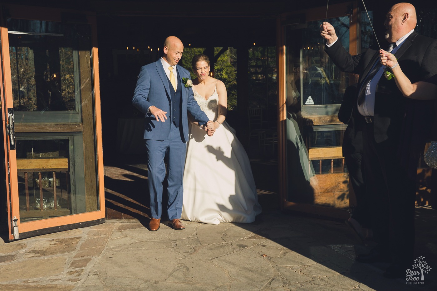 Bride and groom exiting Rocky's Lake Estate and are blinded by the bright sun