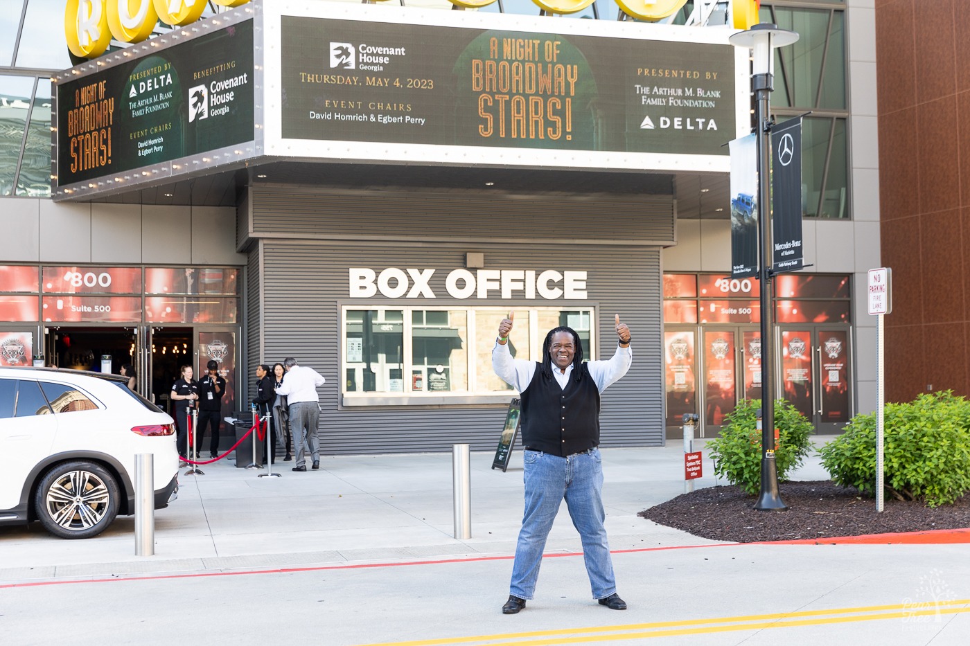 Broadway star Roosevelt Credit standing in front of Atlanta Coca Cola Roxy at the Battery with two thumbs up