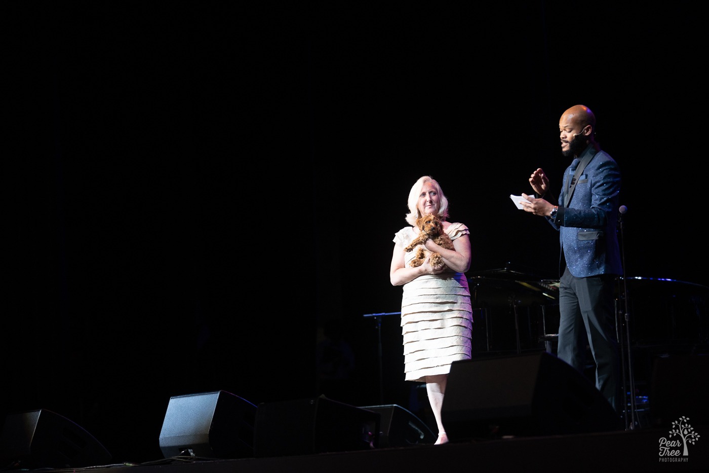 Bid Dawg Auctions Devon Chin onstage to show off a puppy for auction during the Night of Broadway Stars 2023