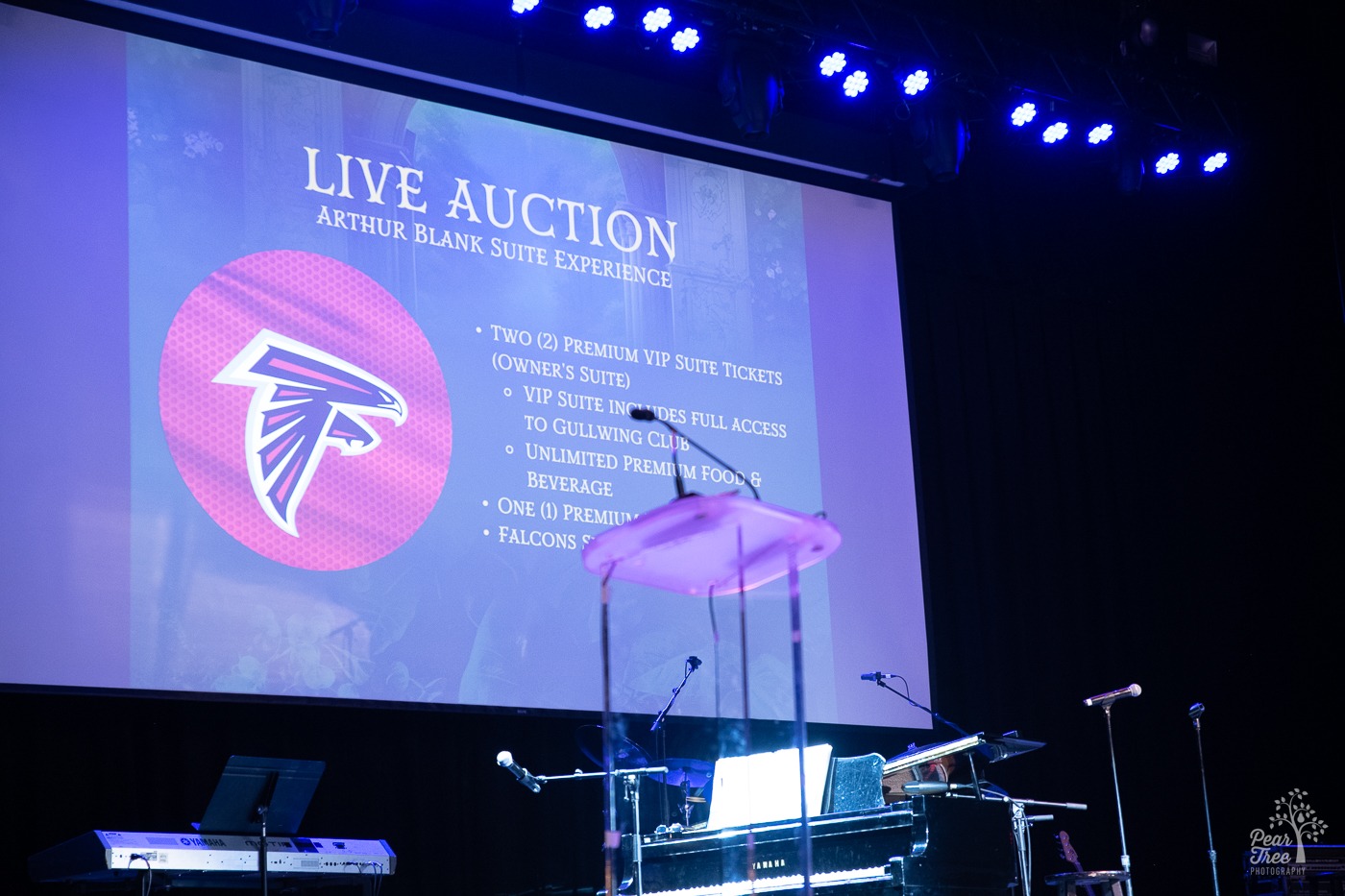 Live auction slide projecteeed of an Arthur Blank Suite Experience up for bid for an Atlanta Falcons game.