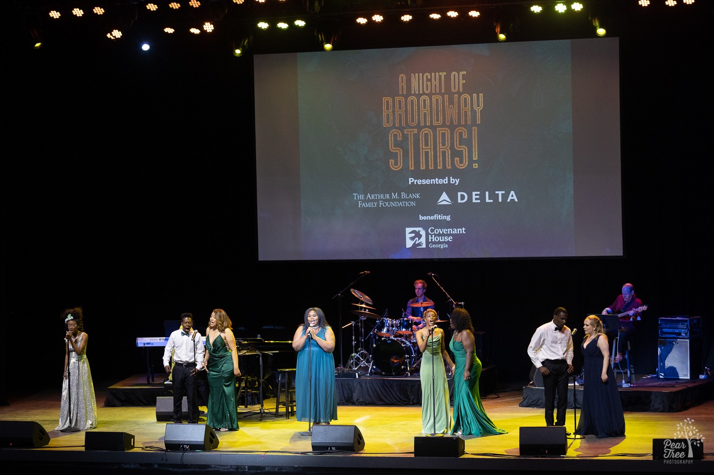 Covenant House Georgia youth standing onstage at Night of Broadway Stars performing a song.