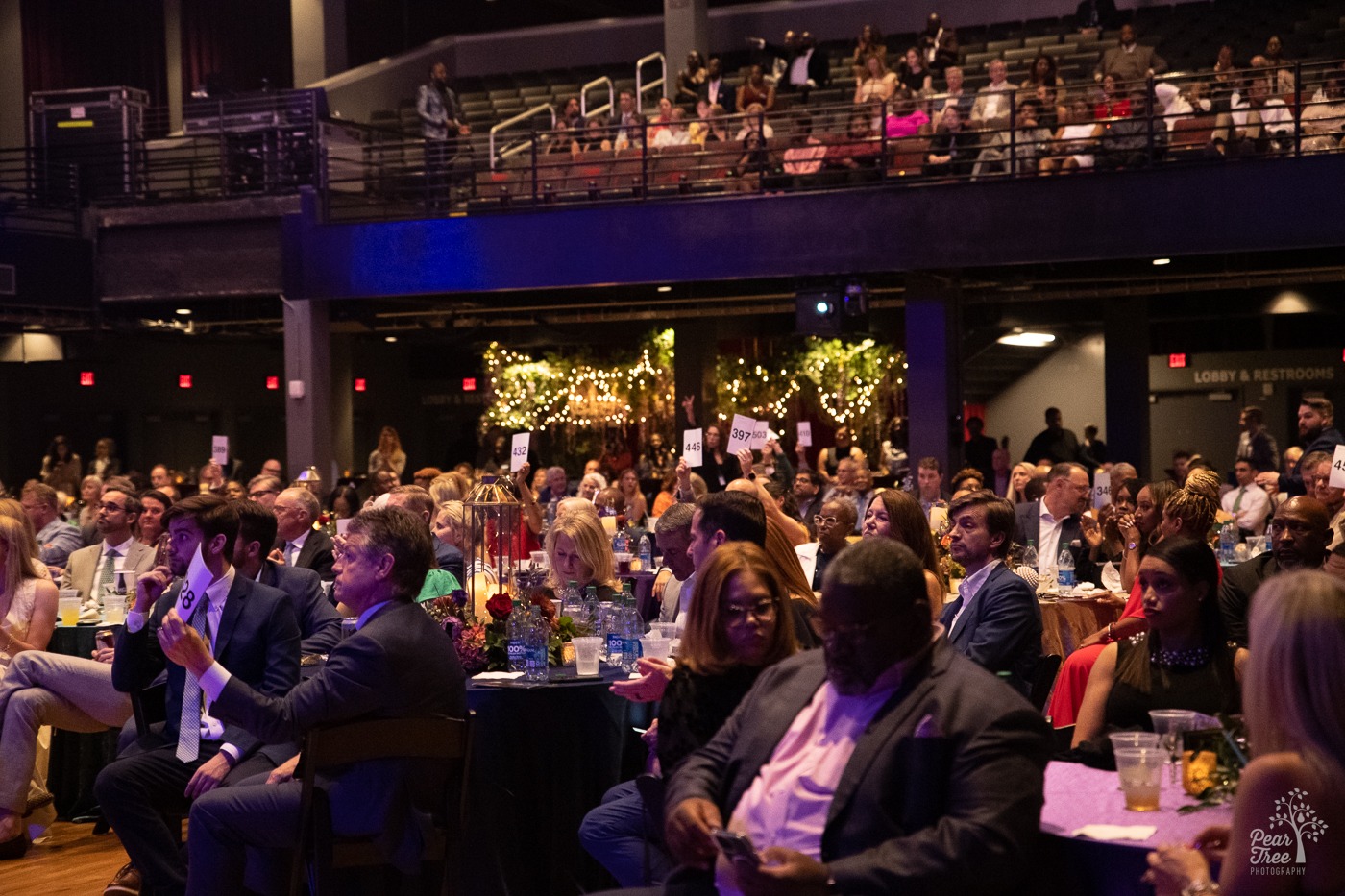 Guests at Night of Broadway Stars 2023 raising their auction numbers to donate to Covenant House Georgia