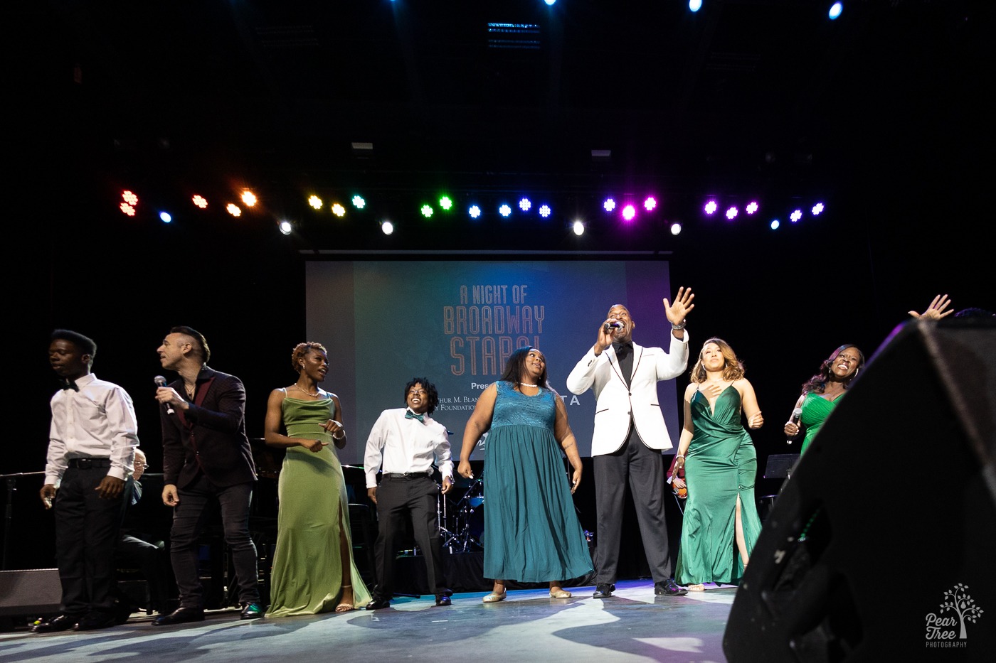 Joey Calveri, Alan Green, and Lakisha Jones singing on stage with Covenant House Georgia youth during Night of Broadway Stars 2023