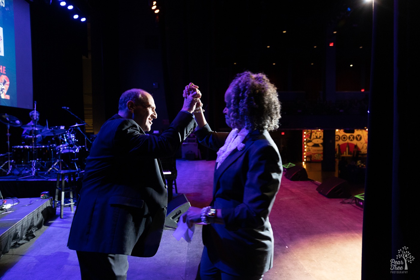 Dr. Alie Redd giving Neil Berg a solid high five hand shake backstage at Night of Broadway Stars 2023.