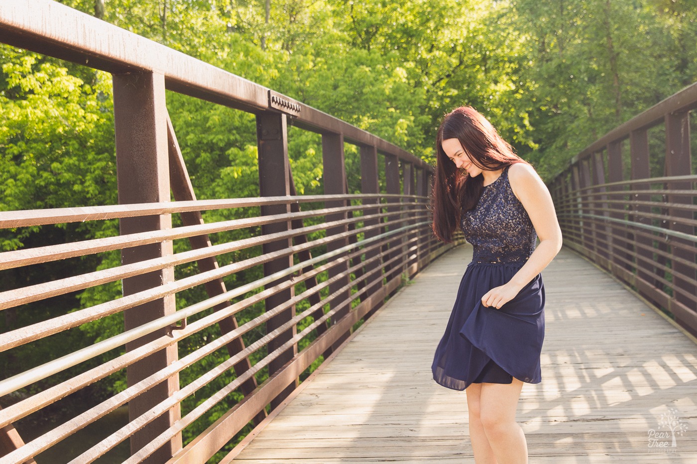 Senior girl dancing and laughing in a blue dress on Olde Rope Mill bridge