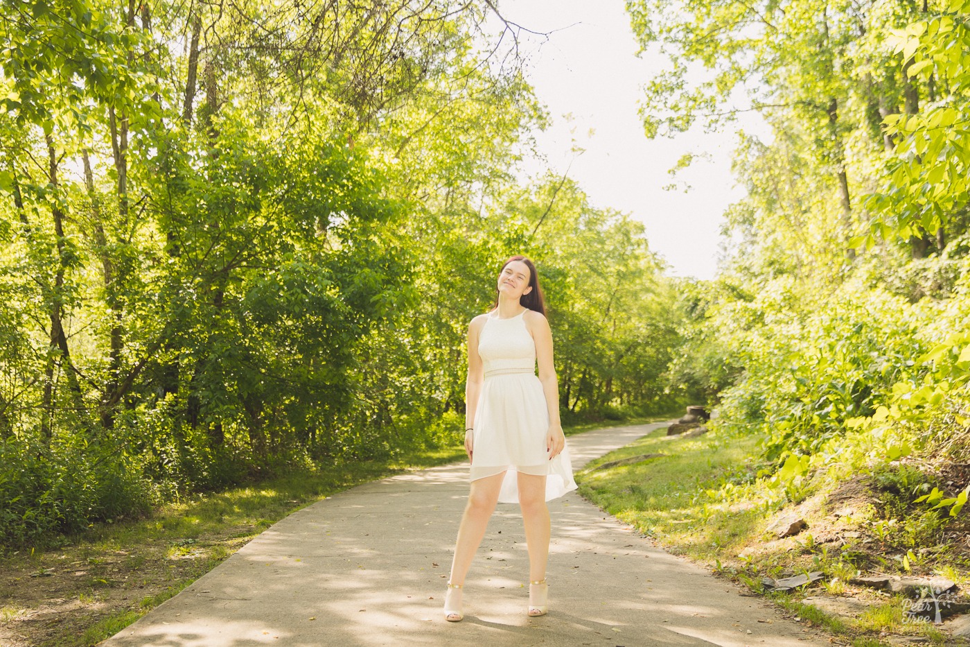 Confident River Ridge High School Senior standing in the middle of a dappled sidewalk at Olde Rope Mill Park