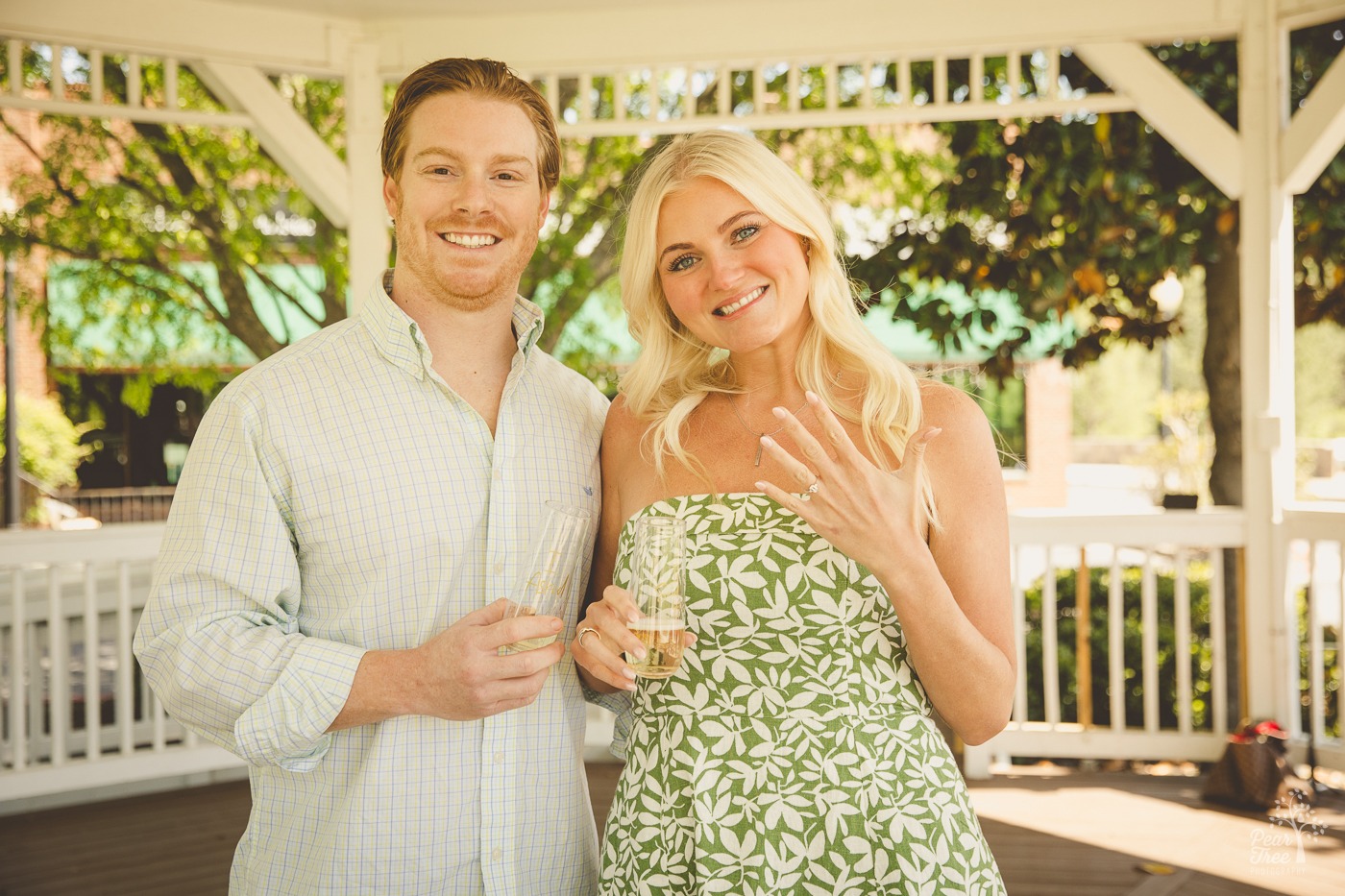 Newly engaged couple with the beautiful blond woman showing off her new ring