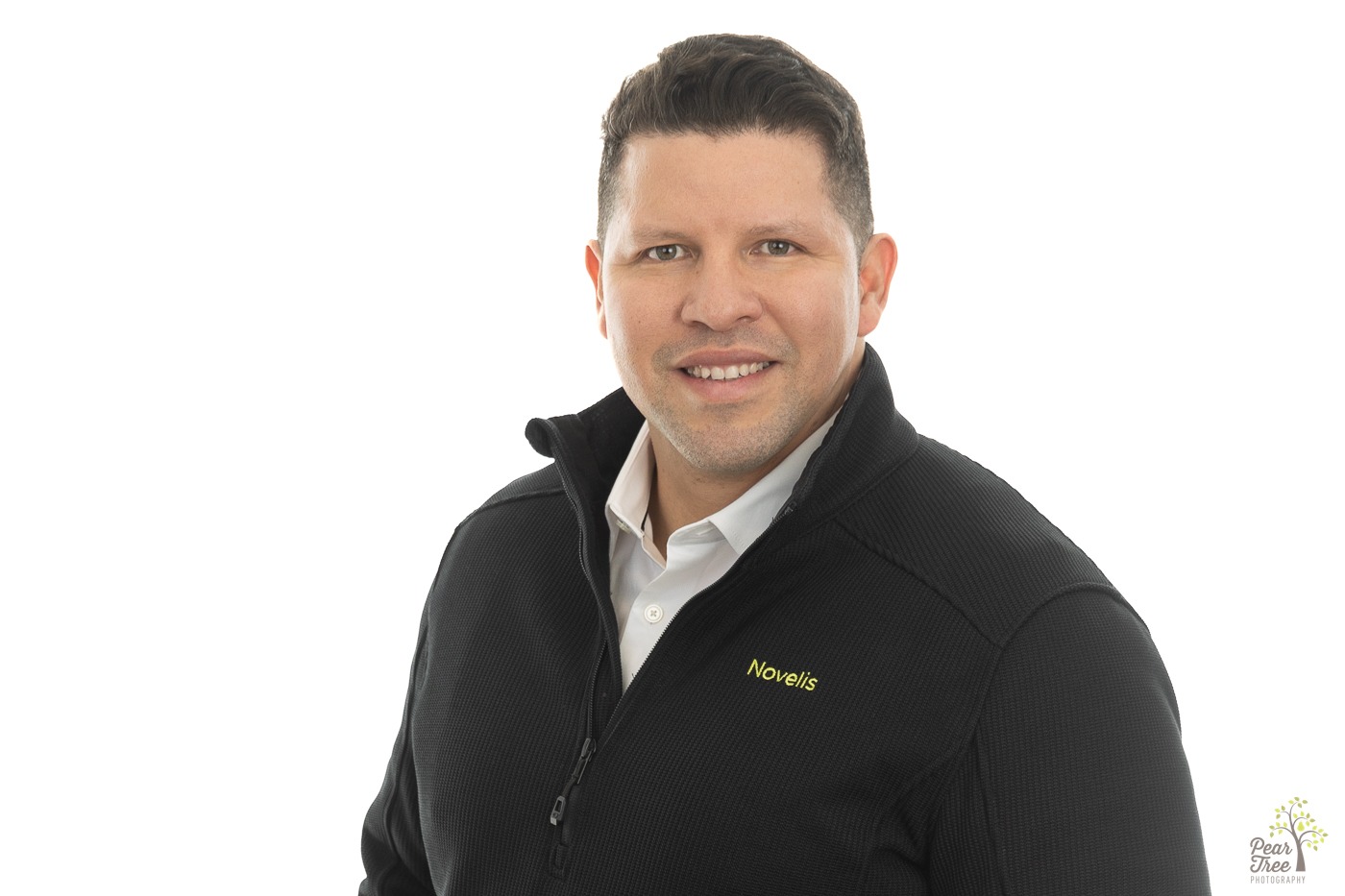 Casual headshot of a man in a dark pullover in front of a white background