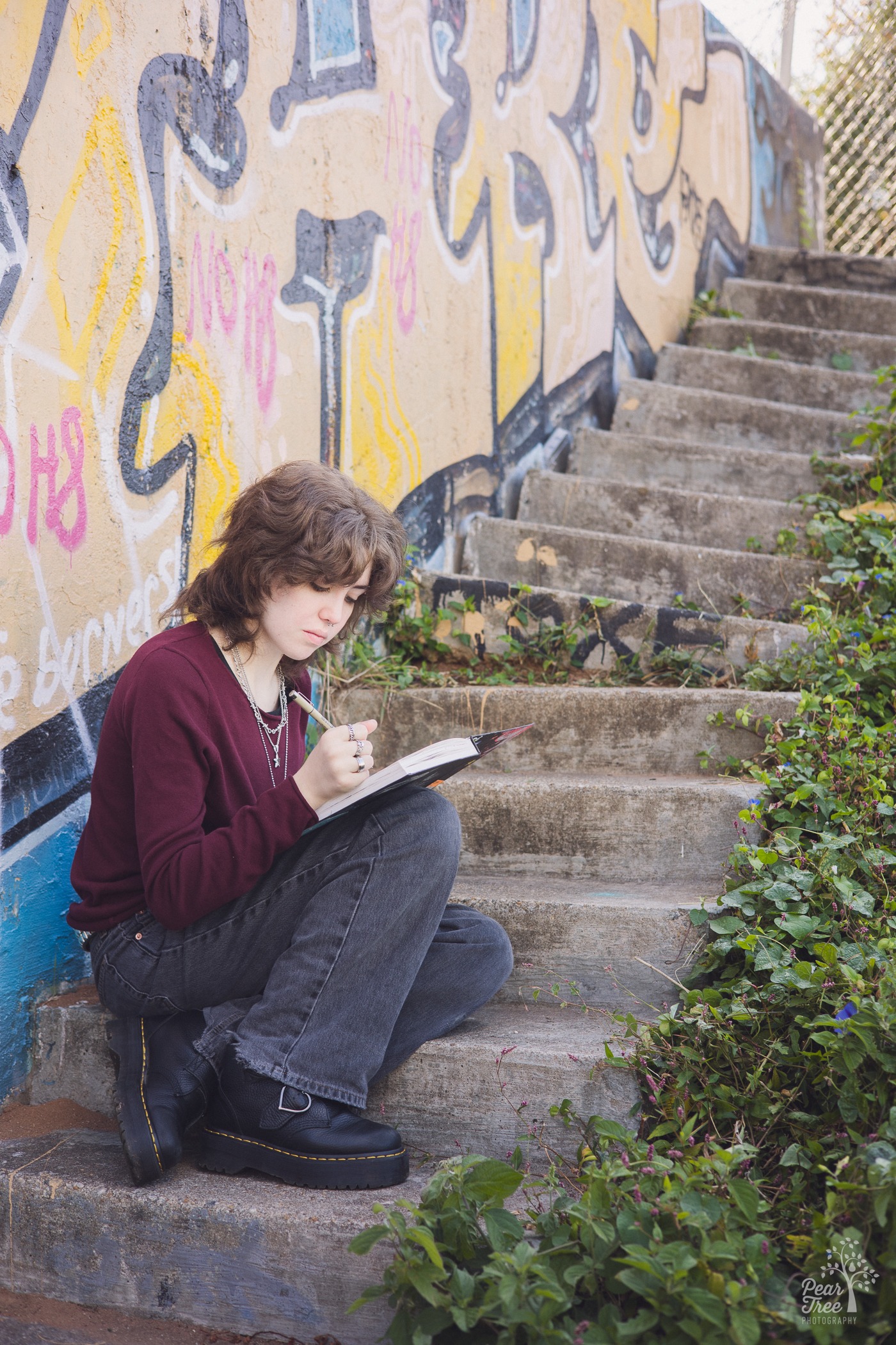 High school senior sitting on cement steps drawing