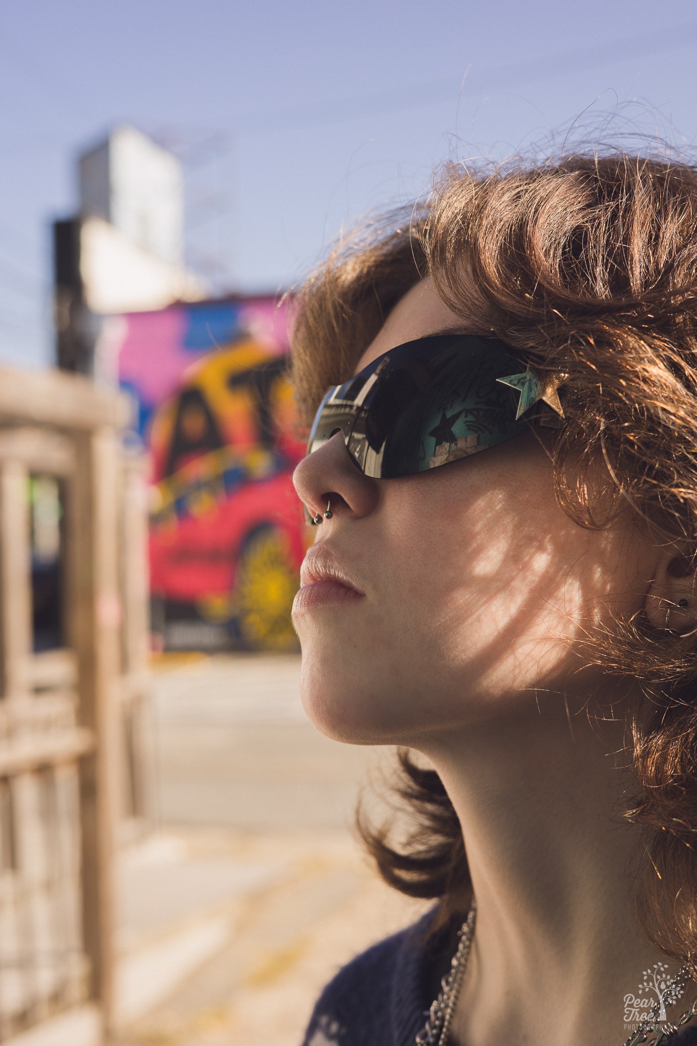 High school senior in sunglasses in Little Five Points with graffiti behind them