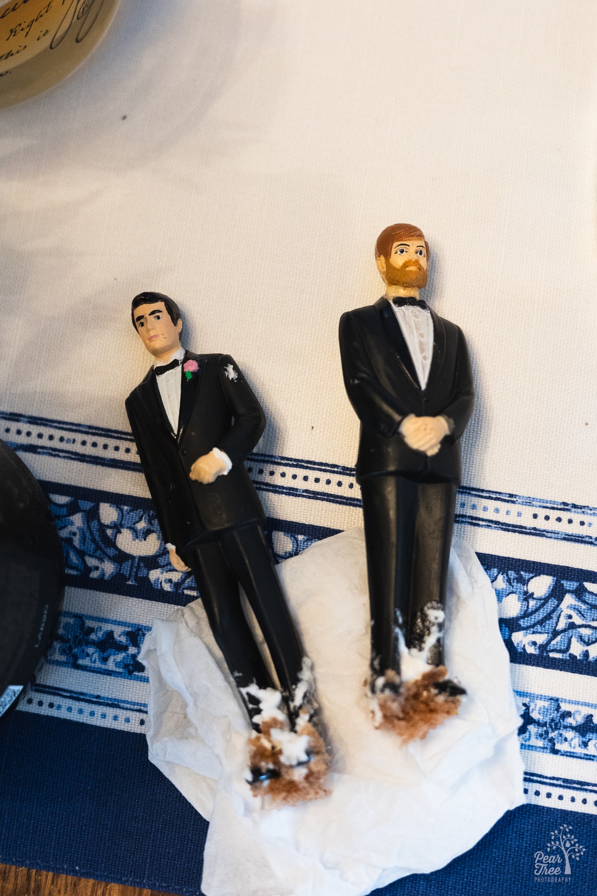 Two groom figurines with cake and icing on their feet and lower legs from an intimate wedding in Midtown Atlanta