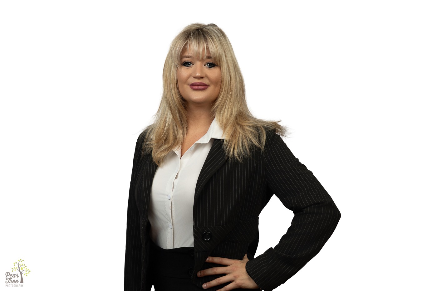 Blonde woman in a pin stripe black suit and white blouse smiling