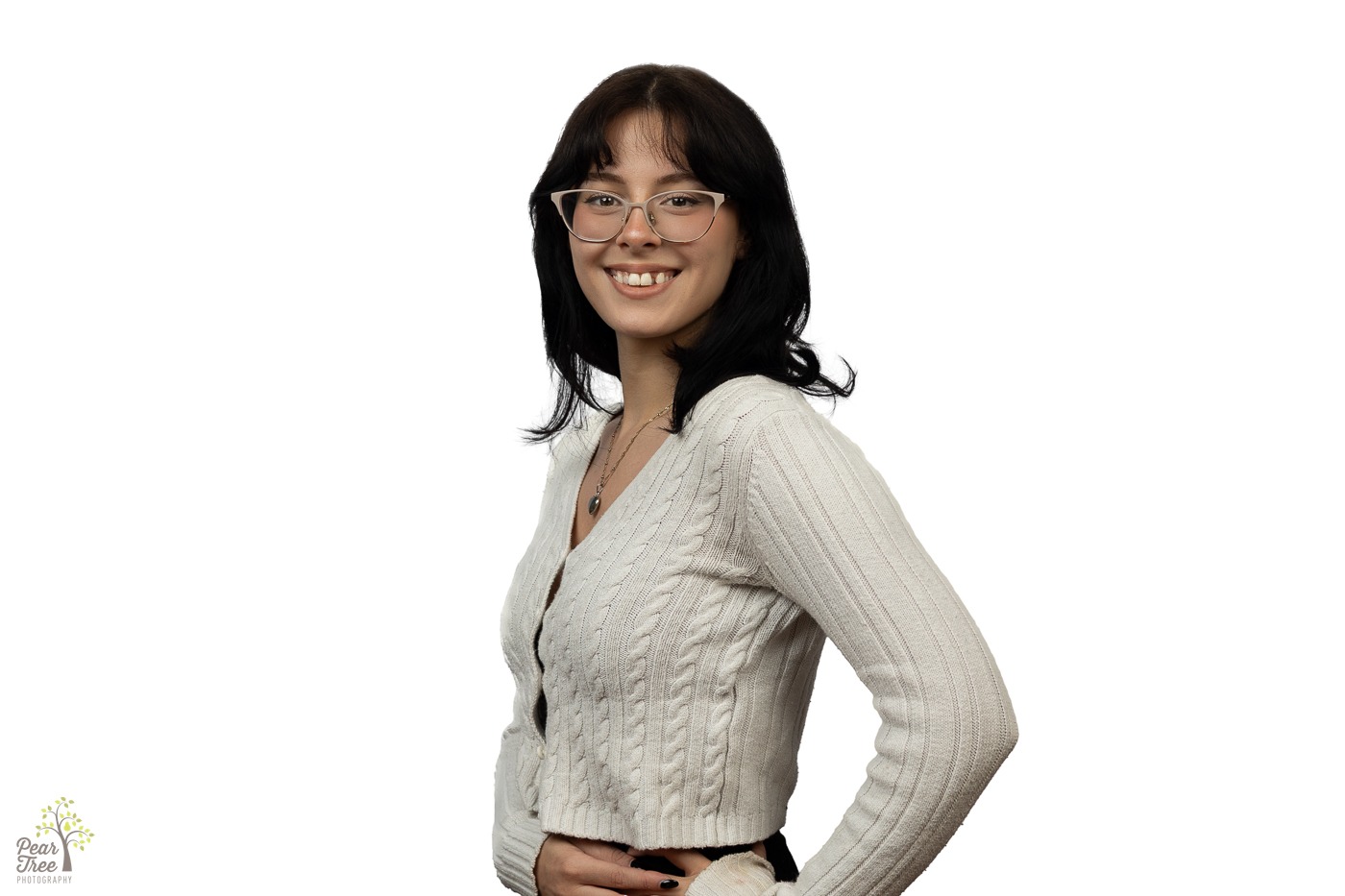 Young woman with cats eye glasses and shoulder length dark hair smiling for a headshot in front of a white background