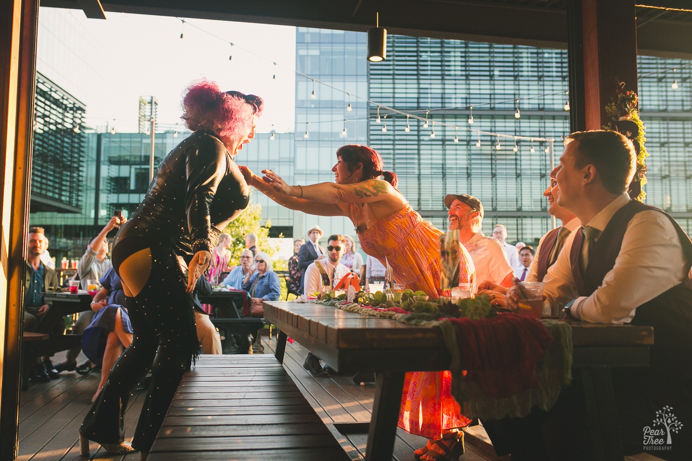 Atlanta wedding guest reaching out to put money in the cleavage of Atlanta drag queen Tugboat at New Realm Brewing Company