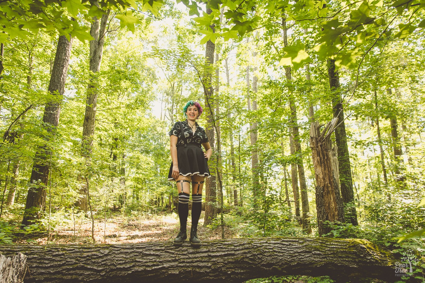 Adairsville senior posing on top of a fallen tree and smiling