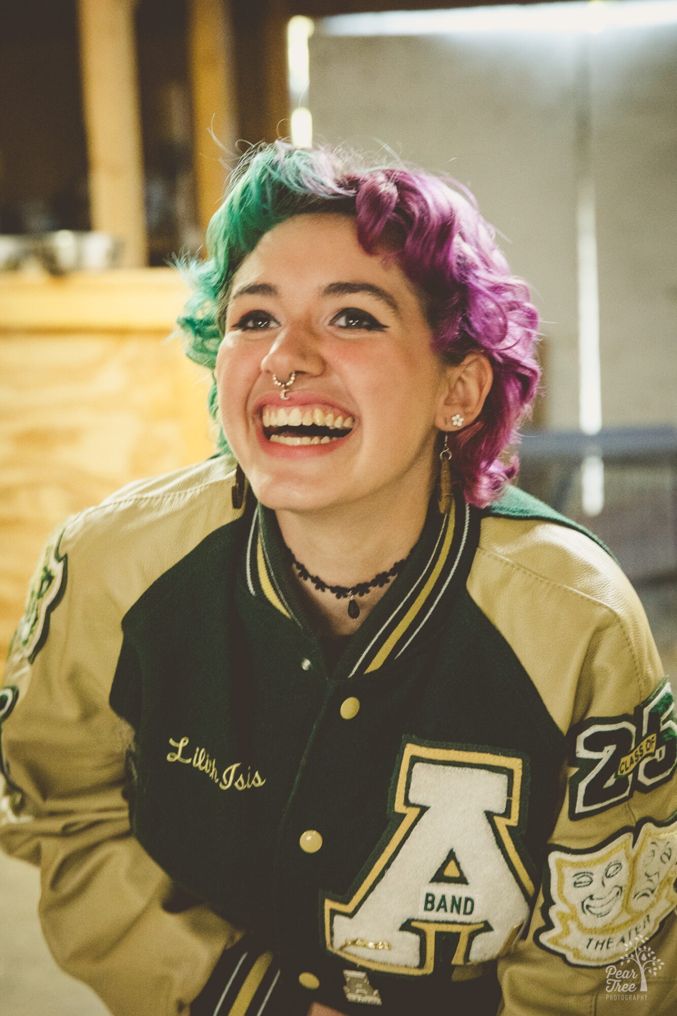 Laughing Adairsville high school senior wearing her letterman jacket with Band and Theatre patches showing