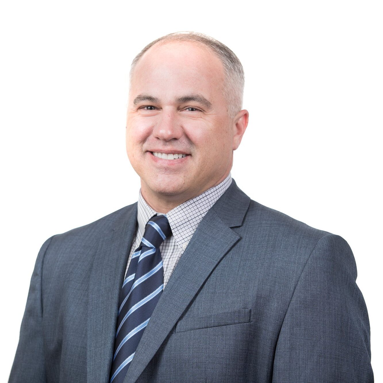 Smiling man in suit and tie in front of white background