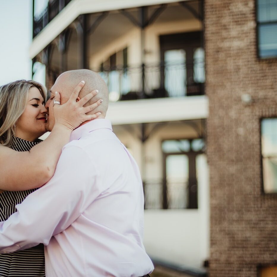 Gorgeous blond pulling her fiance close and holding his head while she goes in for a kiss at Avalon during their engagement session
