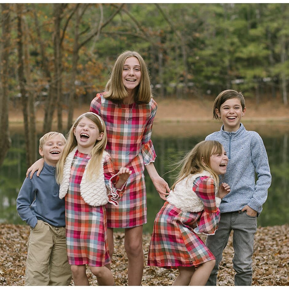 Five young cousins laughing hysterically while dressed for fall at the lake