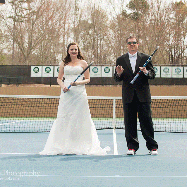 Bride and groom on tennis court holding tennis racquets and avoiding dozens of tennis balls coming at them