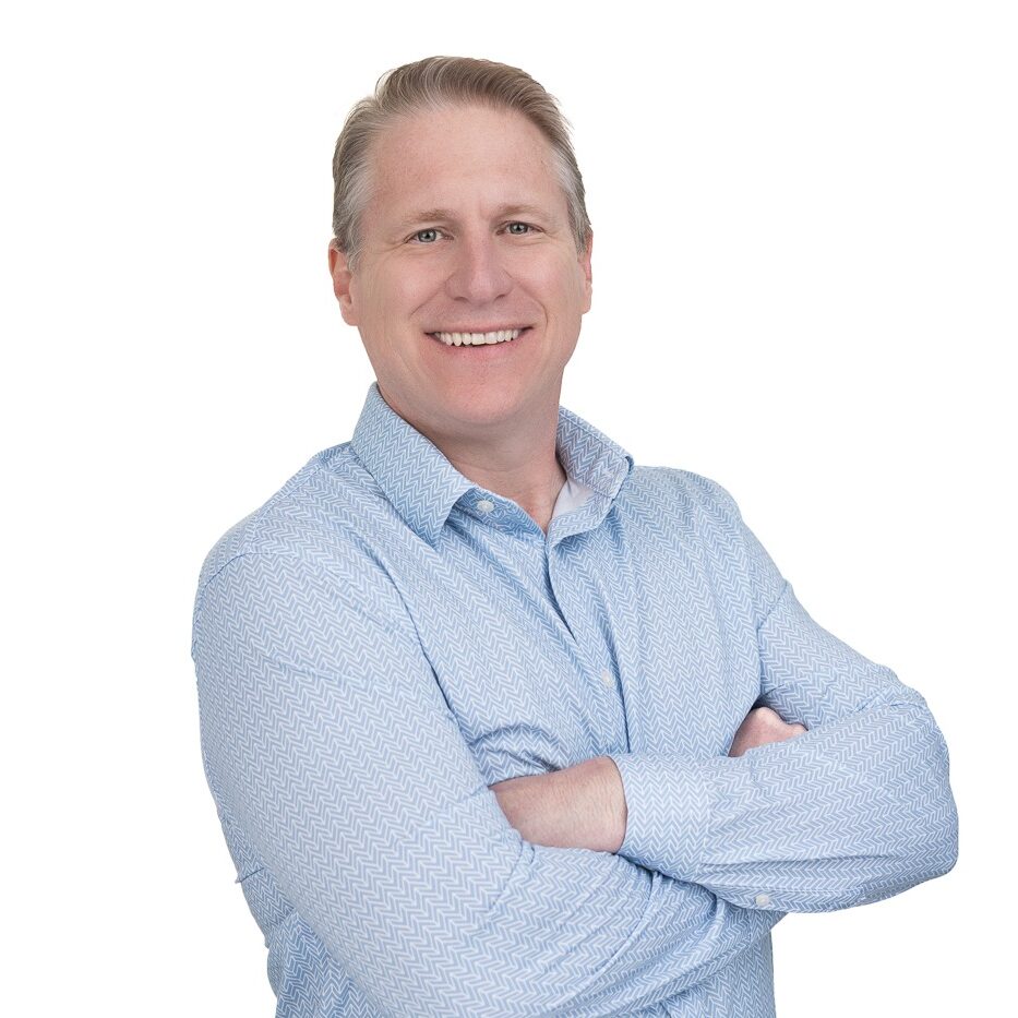 Professional headshot of a man in Kennesaw wearing a blue shirt and smiling in front of a white background
