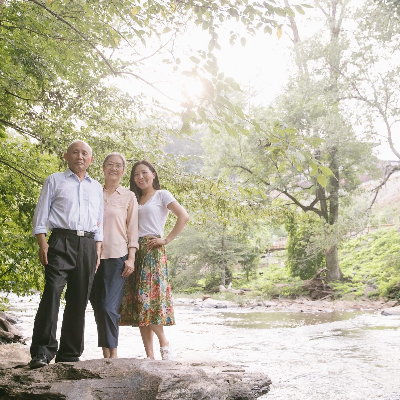 Chinese parents standing with their adult daughter at Vickery Creek near Roswell Mill