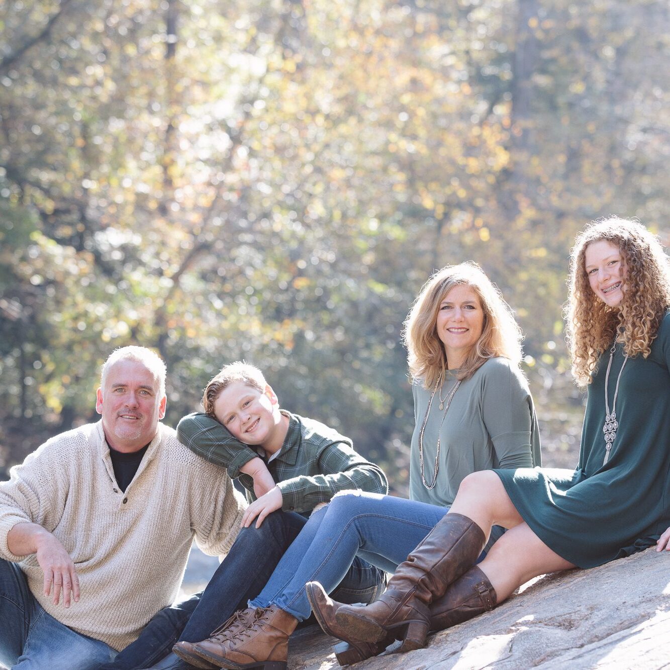 Family of four with two teenagers sitting on the shoals at Sope Creek in the morning sun