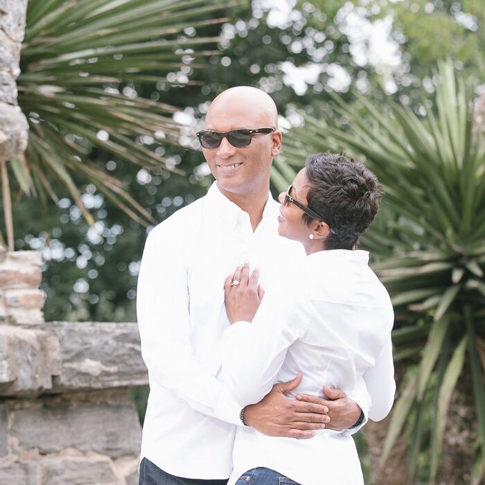 Engaged couple wearing sunglasses and hugging inside Atlanta Botanical Garden