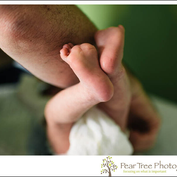 Newborn feet up in the air right before a diaper change